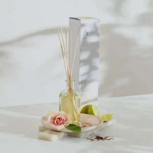 Arran After The Rain reed diffuser with natural reeds beside rose and lime