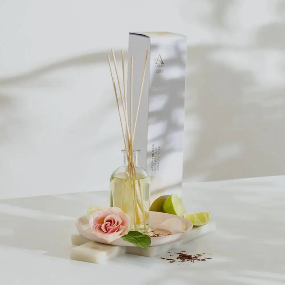 Arran After The Rain reed diffuser with natural reeds beside rose and lime