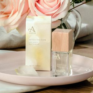 Mini bottle of Arran After The Rain perfume surrounded by roses