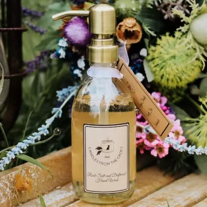 Candles from the Croft 300ml glass hand wash bottle with brushed gold pump surrounded by flowers