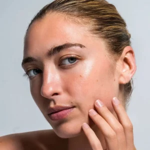 Model with glowing skin applying Repêchage Peptide Serum – luxury age-defying skincare.