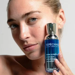 Close-up of model holding Repêchage Peptide Cream – glowing hydrated skin.