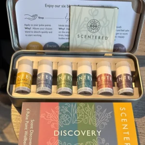 Open Scentered Aromatherapy Discovery Tin containing six mini balms, ritual information and colourful Discovery packaging.